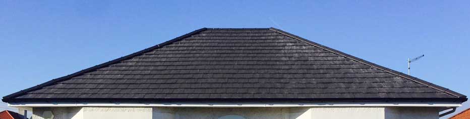 Wide view of slate roof, with black gutters and downpipes